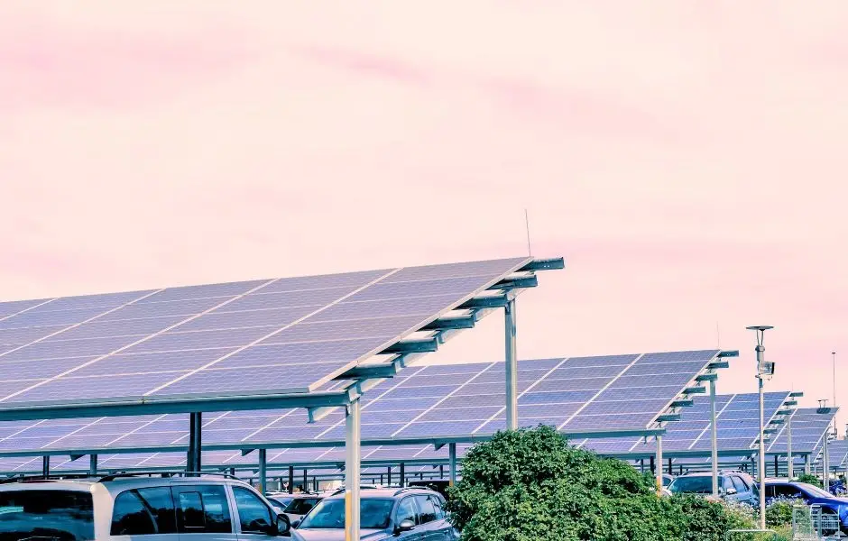 Ombrières photovoltaïques au-dessus d'un parking, au crépuscule