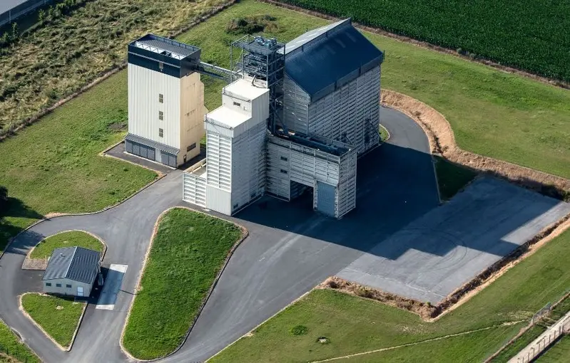 Vue aérienne de silos et de bâtiments agricoles entourés de prairies