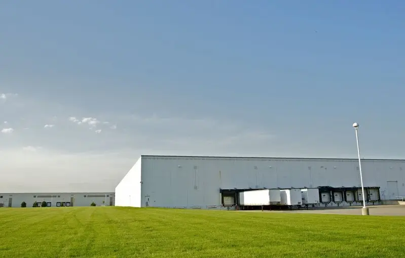 Bâtiment logistique bordé de pelouse dans une zone d'activité